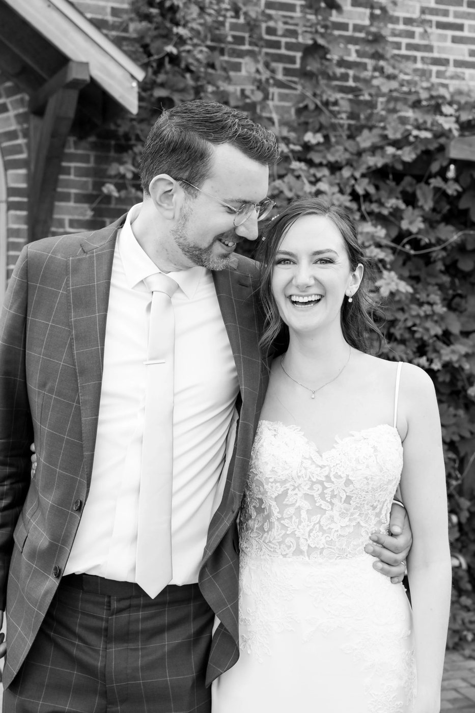 Black and white portrait of a bride and groom laughing at a Michigan wedding